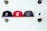 Four baseball caps are neatly lined on a wooden shelf against a white brick wall. Each cap features an embroidered bear logo. The caps are in black, red, dark gray, and white colors.