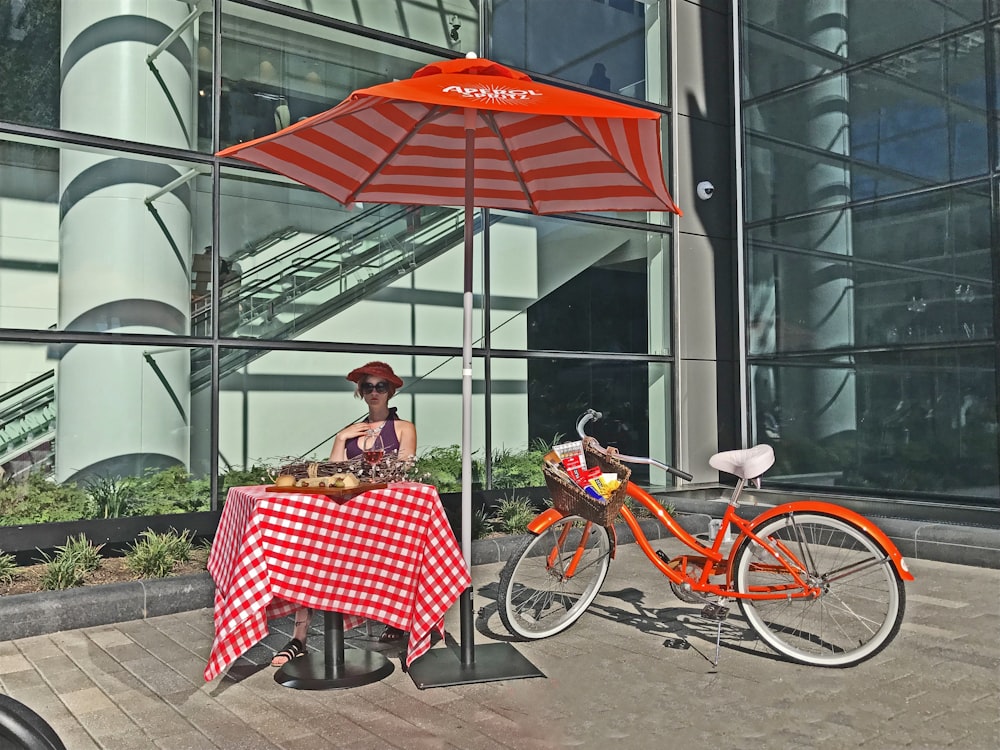 woman sitting under red parasol