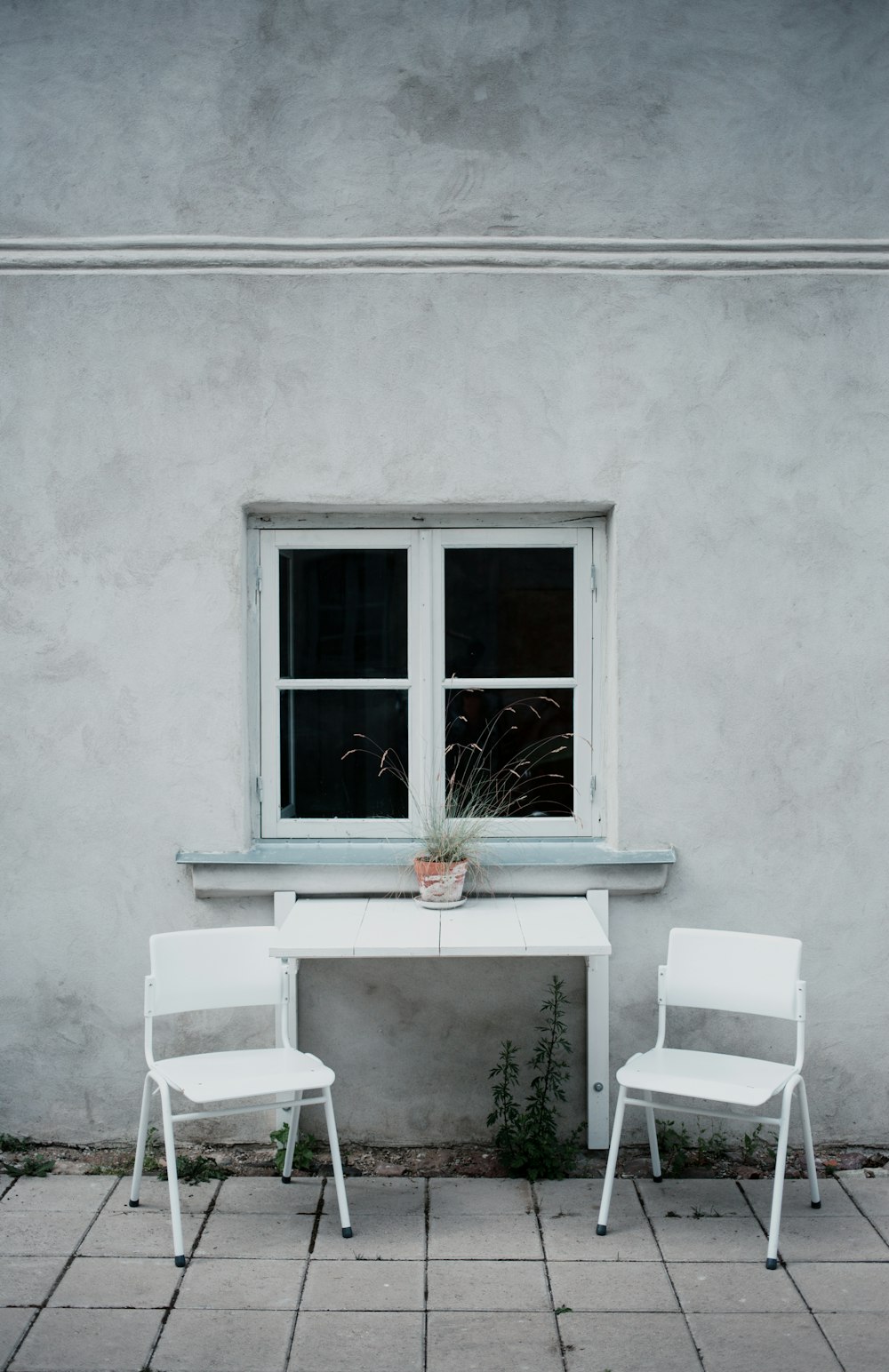 two white folding chairs beside wall