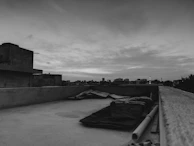 Black and white picture of urban rooftops from a high angle at dusk.