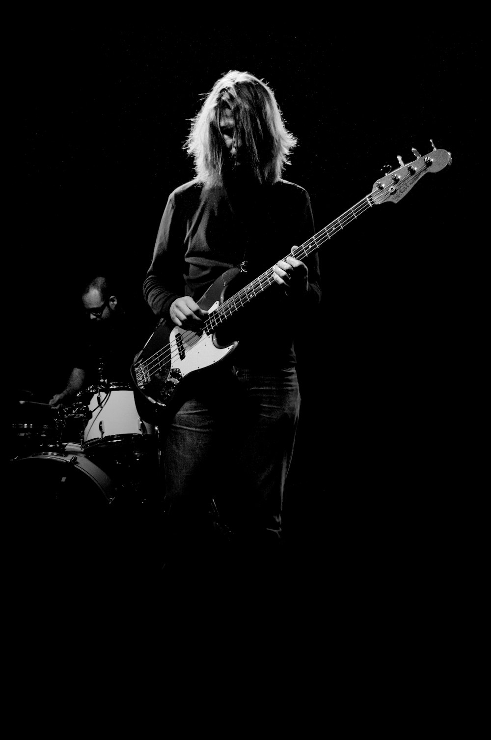 man playing electric bass guitar in grayscale photography