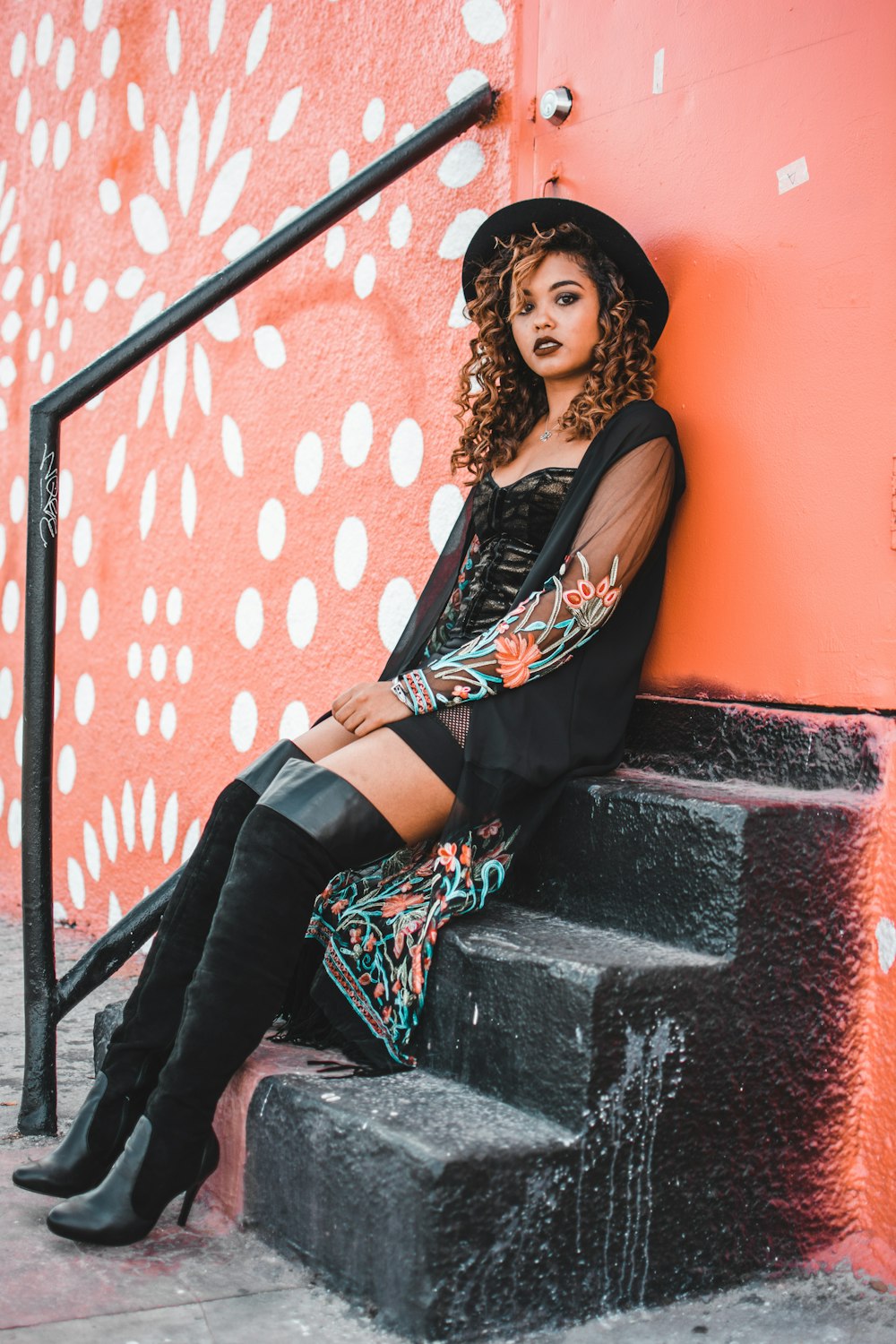 woman wearing black mini dress and black thigh-high boots sitting in front  of closed door photo – Free Miami Image on Unsplash