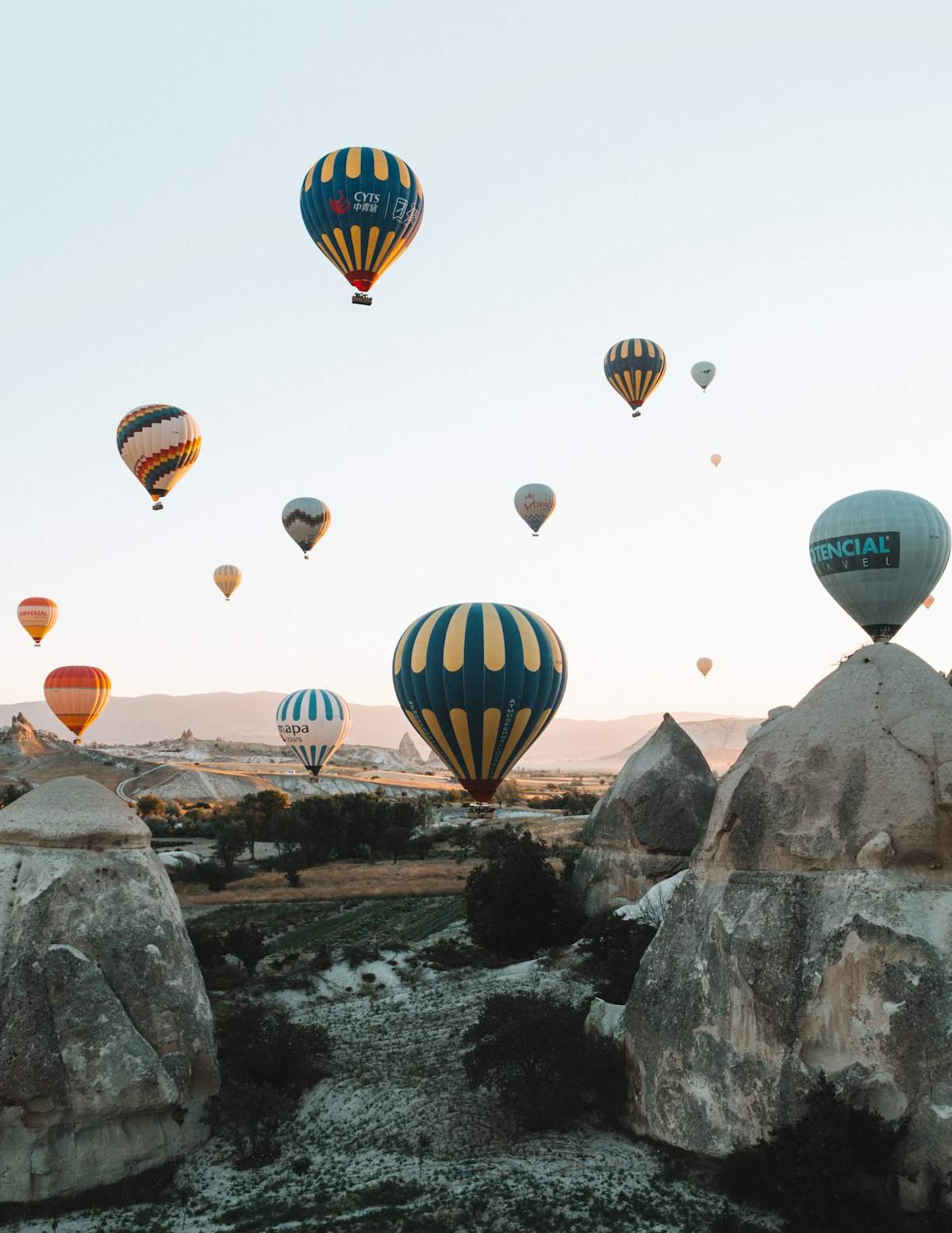 Cappadocia October — the rose and ochre valley landscape in autumn with balloons rising in the morning mist