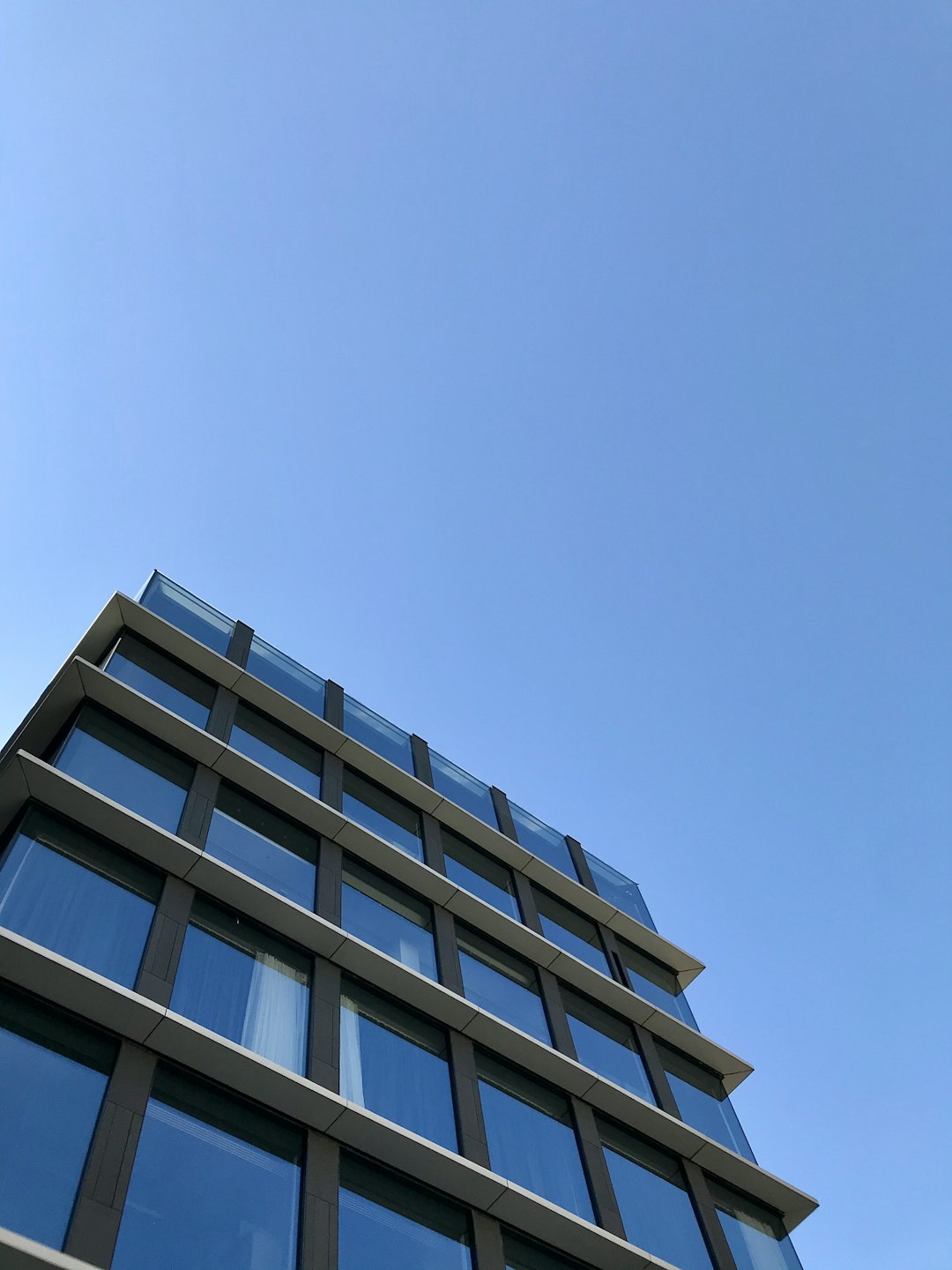 low-angle photography of blue glass walled building