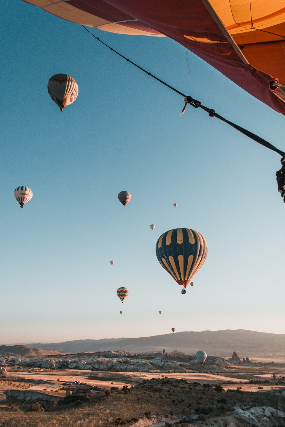 multicolored hot balloons above mountain during daytime