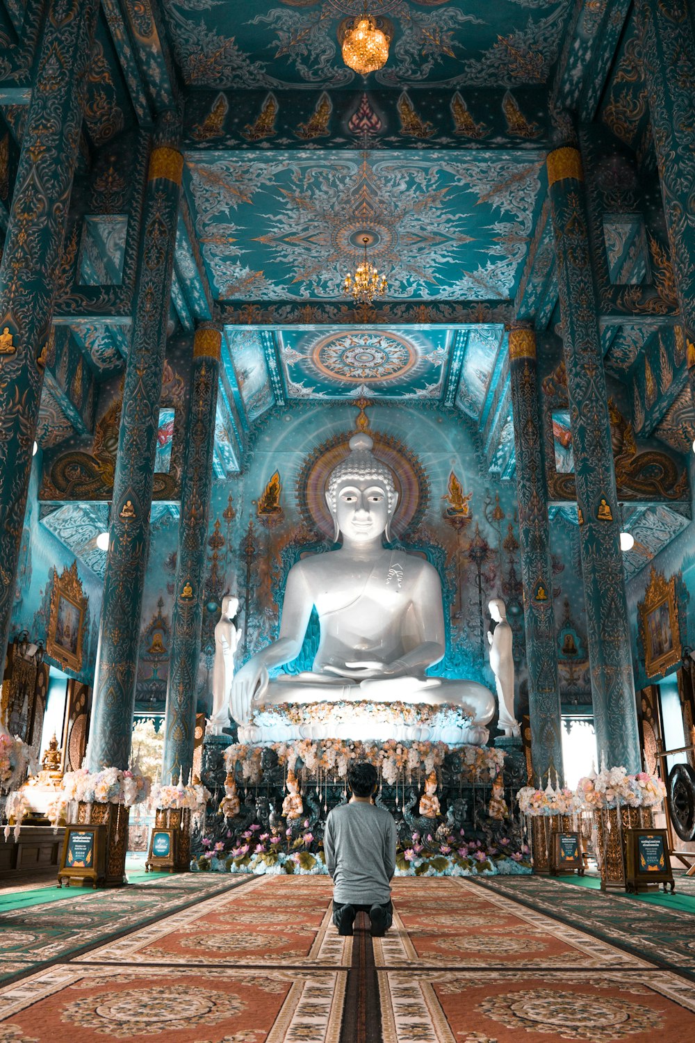 personne s’agenouille près de Bouddha