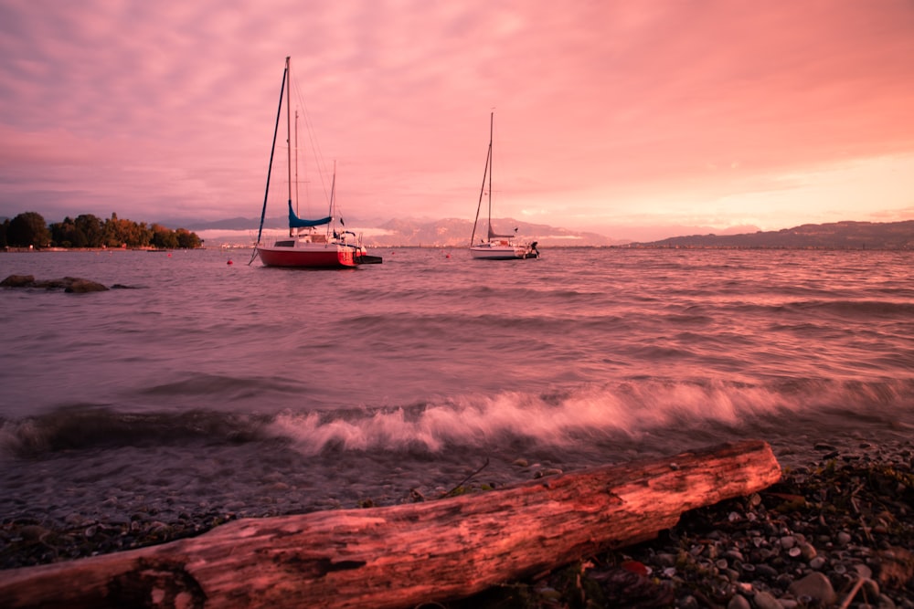 a couple of boats floating on top of a body of water