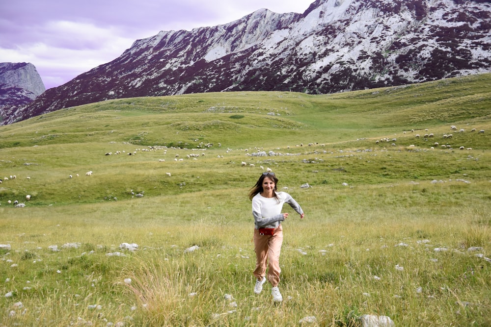 woman wearing whiten and gray sweater on grass during daytime