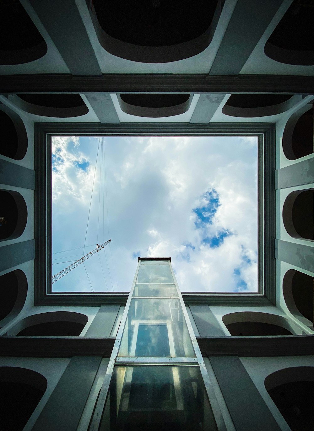 low-angle photography of white and gray building under white and blue skies during daytime