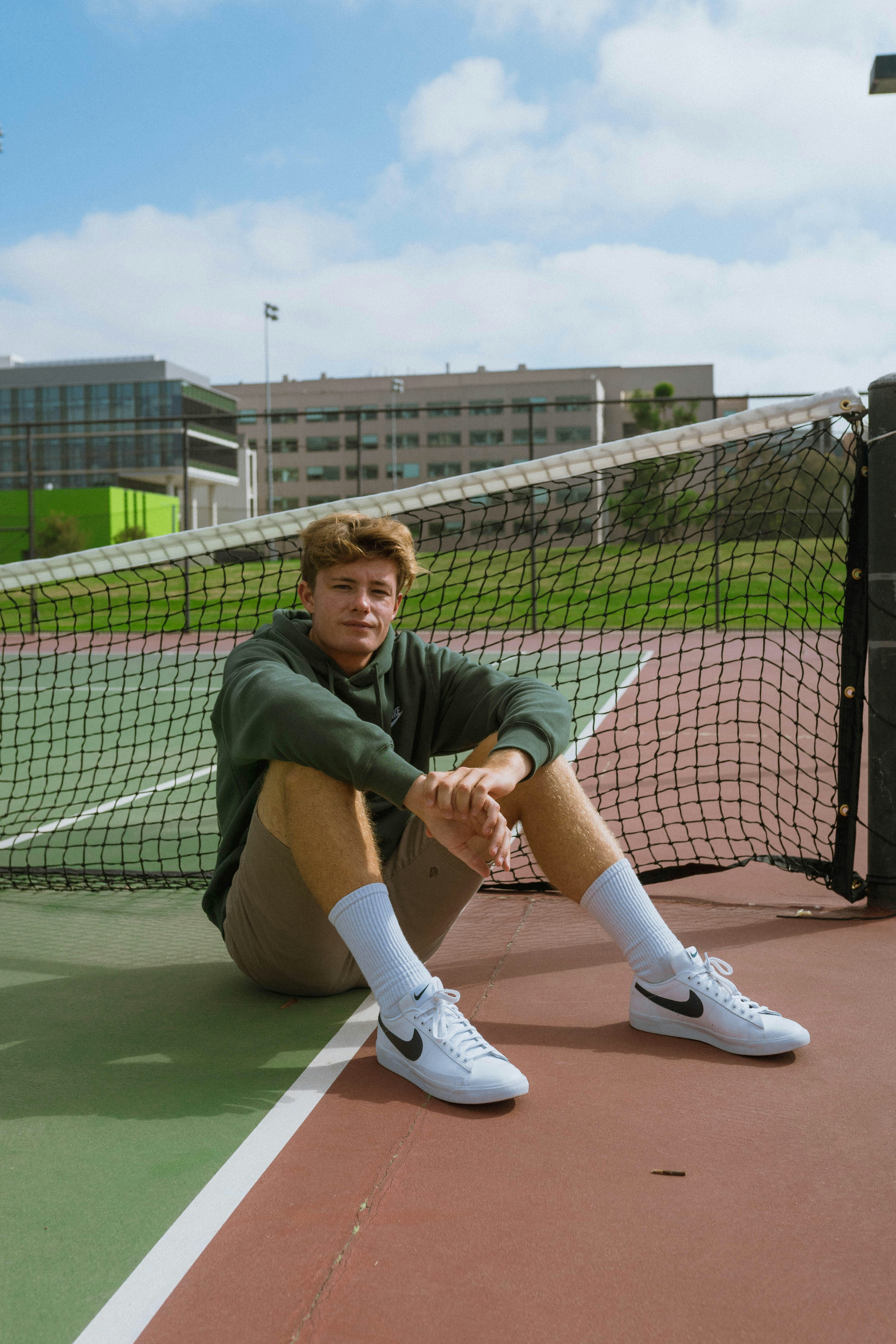 man sitting behind tennis net