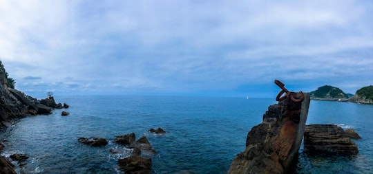 aerial photography of rock near sea under blue and white skies during daytime in San Sebastián Spain