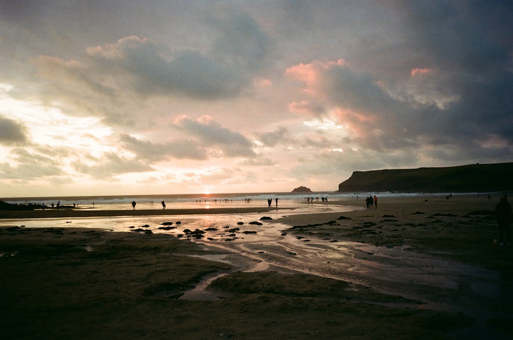 people near seashore under white and gray skies