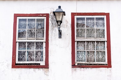 turned-off sconce lamp between two windows colonial google meet background