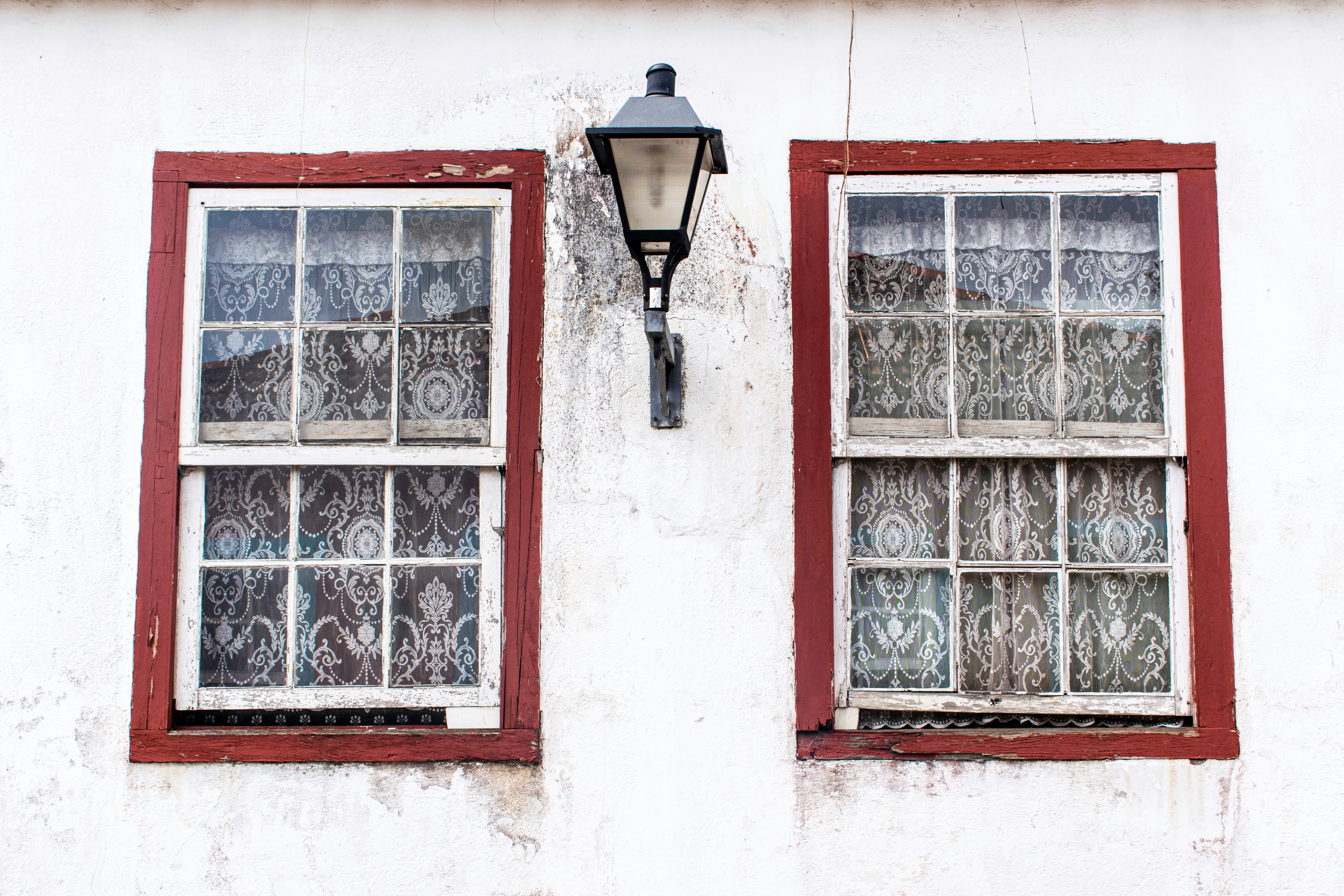 turned-off sconce lamp between two windows