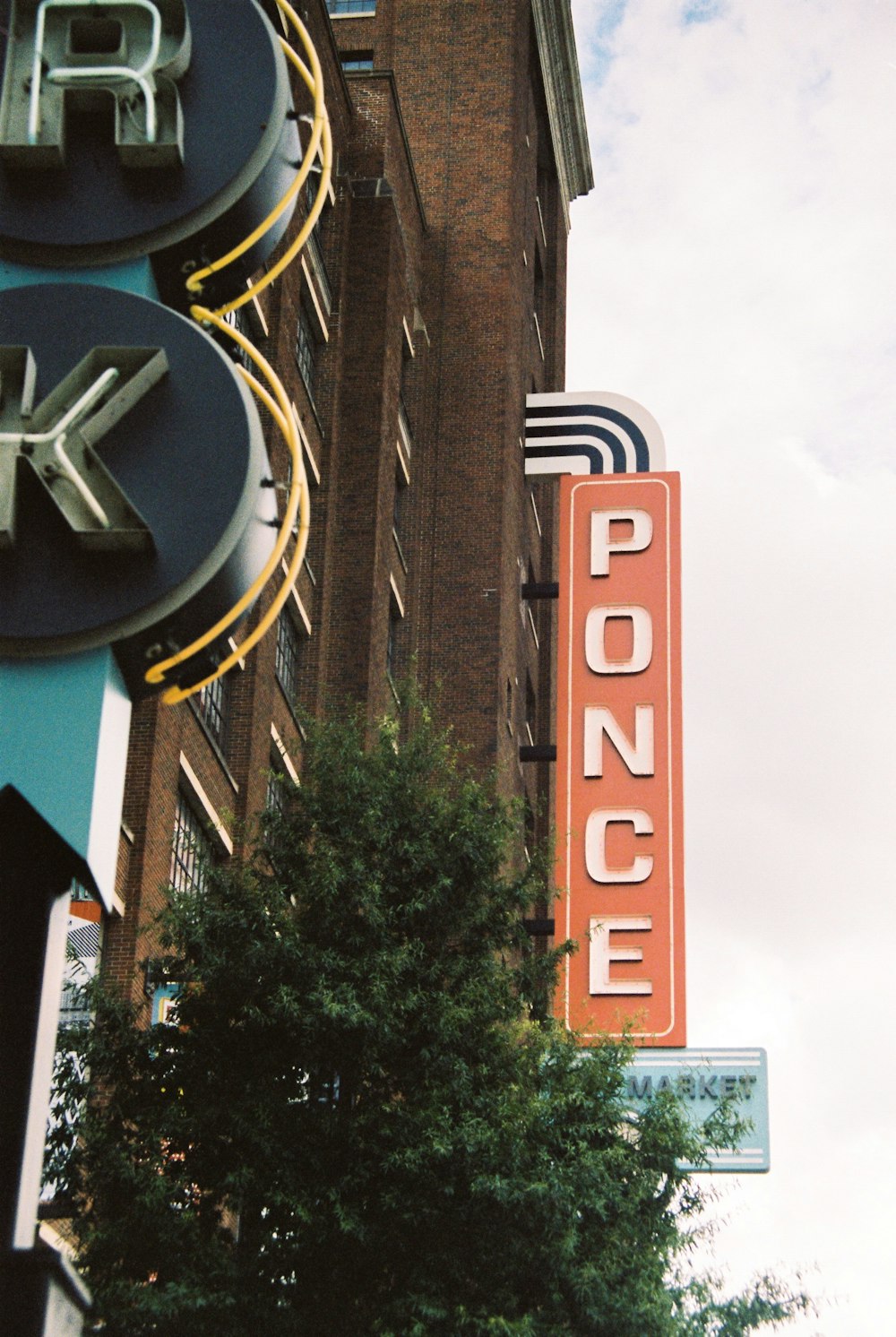 green tree under Ponce building sign during daytime