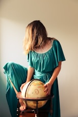 woman standing beside terrestrial globe