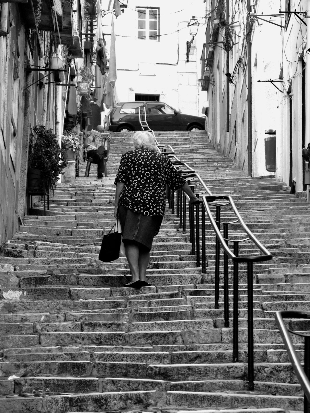 greyscale photo of woman climbing staircase