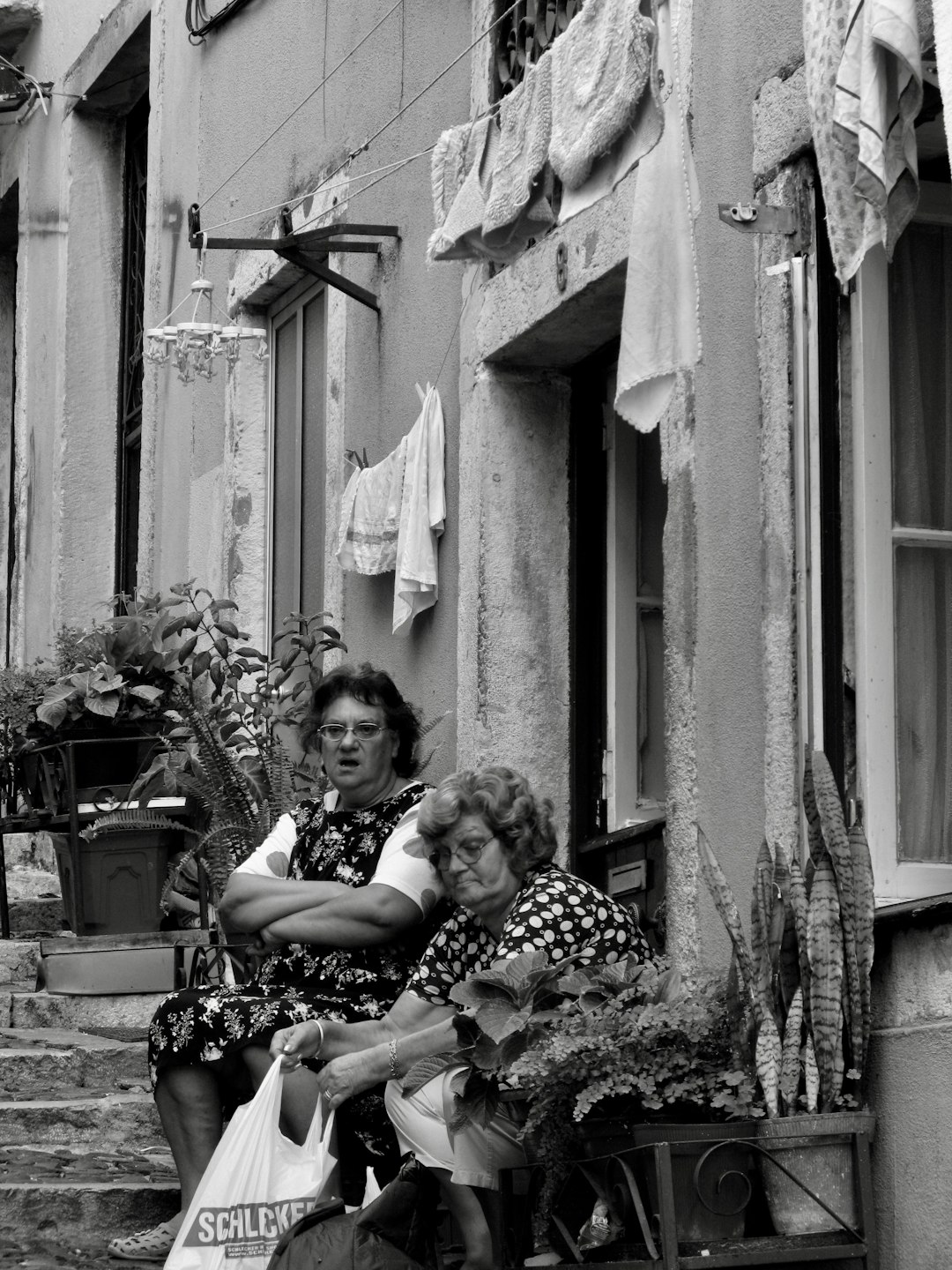 greyscale photo of two women sitting outside