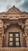 Close-up of a beautifully carved wooden door at the temple entrance.