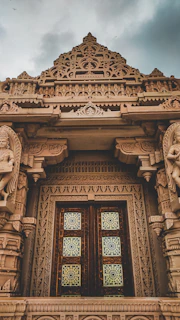 Close-up of intricate traditional carvings on the temple’s wooden doors.