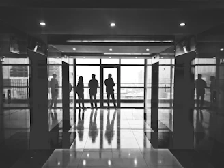 grayscale photography of three person in building