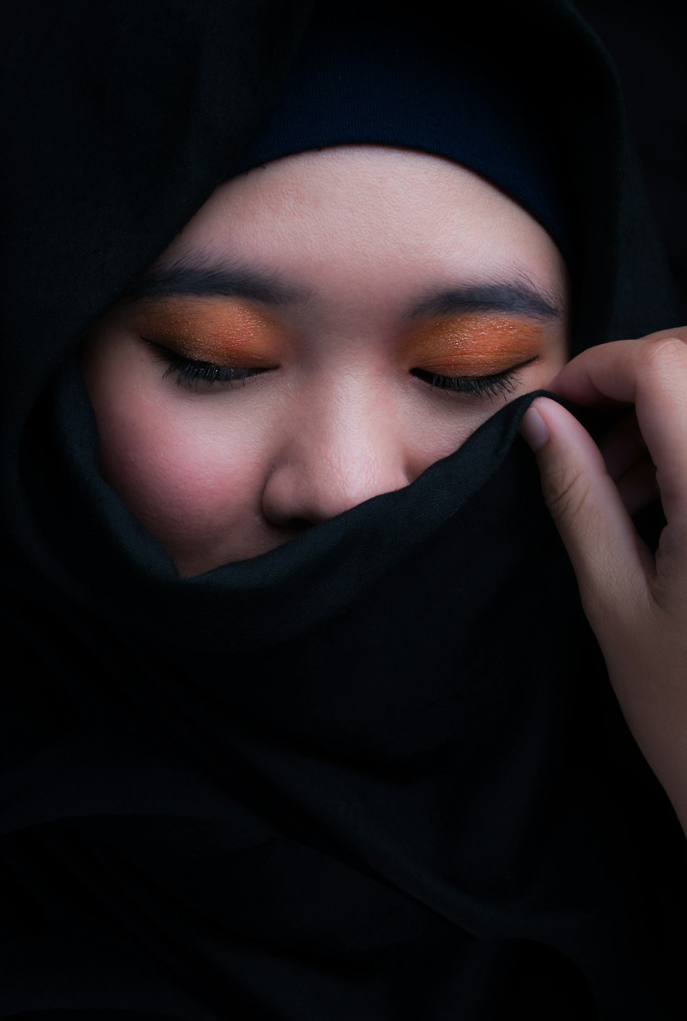 donna che si copre il viso con hijab nero