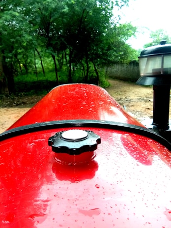 Close-up of a freshly washed tractor in a rural setting, highlighting the shine on the metal parts.