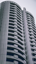 A sleek modern luxury residential building designed by Bilkent Mimarlık, showcasing elegant black, white, and gold accents.