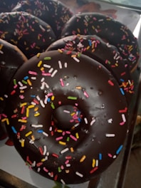 Close-up of colorful mini donuts arranged on a rustic wooden platter.