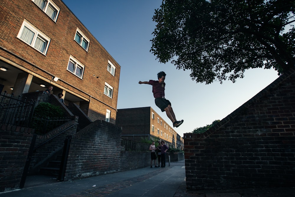 person jumping to brick wall