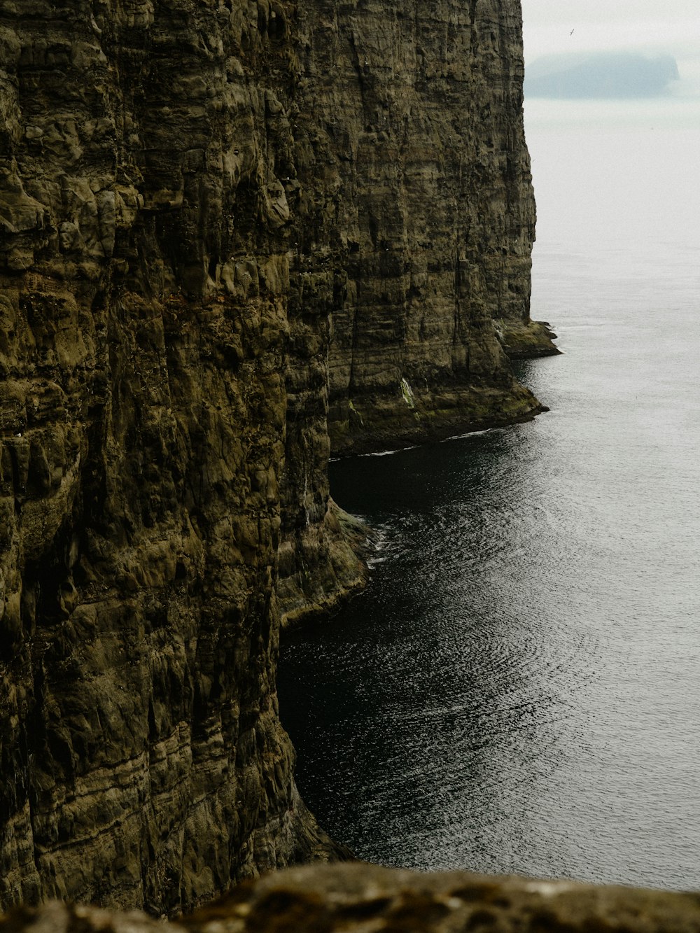 brown cliff besides body of water