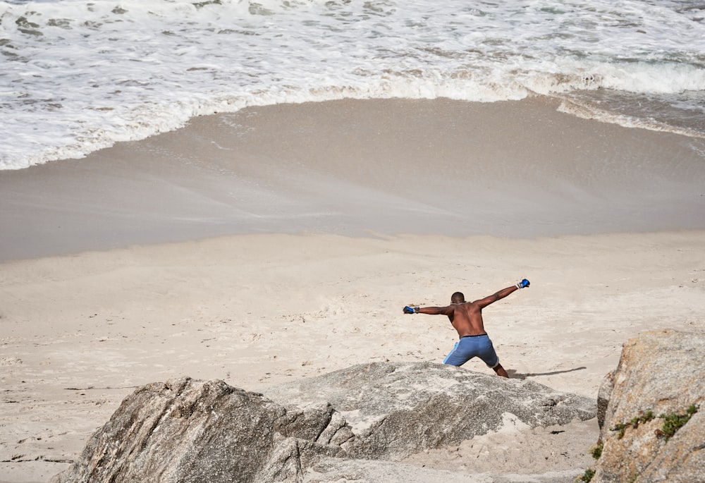 Mann mit blauem Brett bei einem kurzen Spaziergang am Meeresufer
