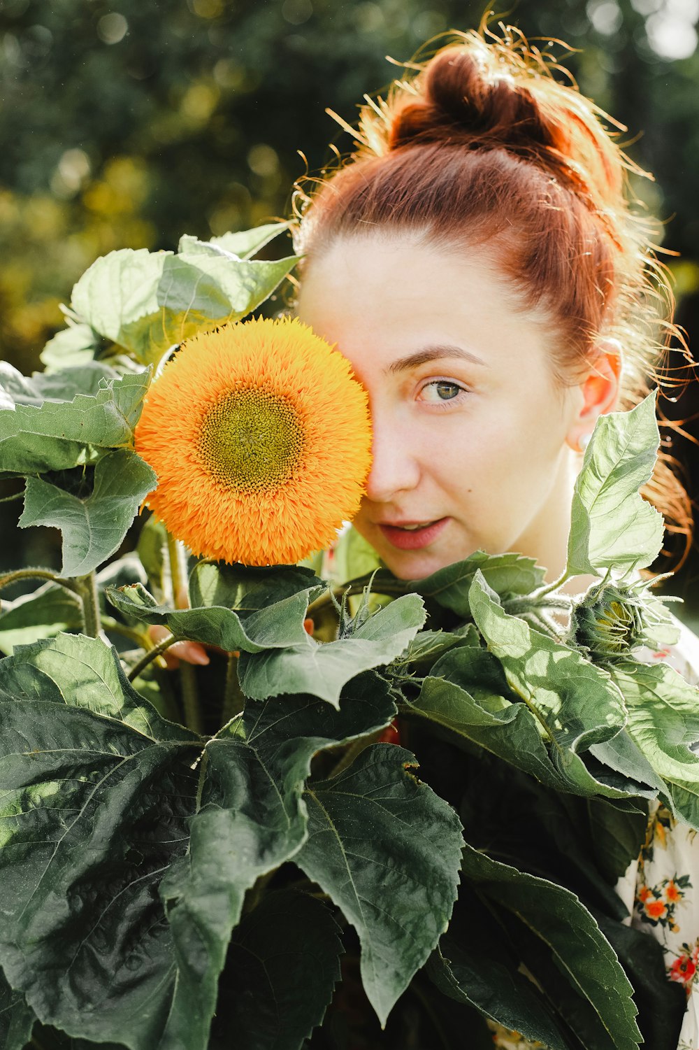 woman hiding behind orange flower
