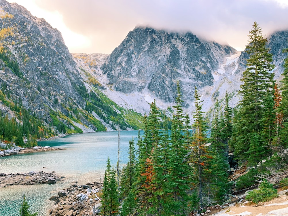 blue lake between mountain during daytime