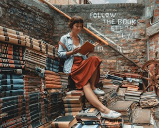 woman wearing denim jacket reading book