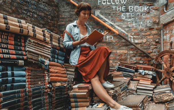 woman wearing denim jacket reading book