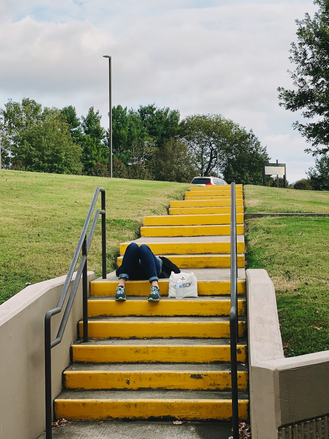 person lying on concrete staircase