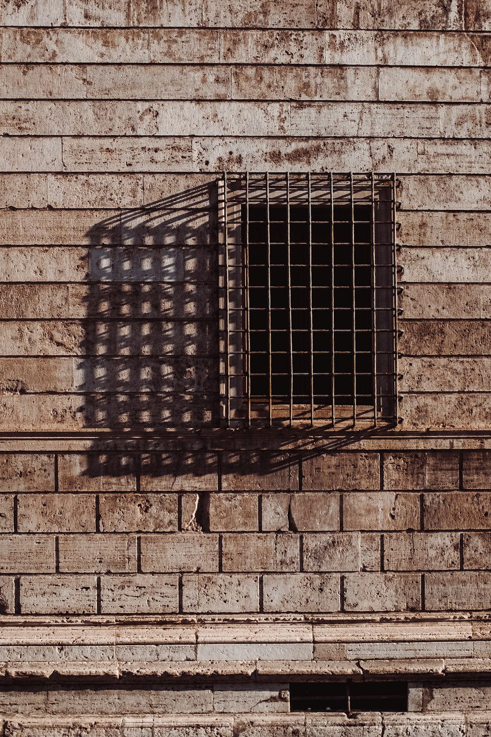 brown metal window frame and brick wall