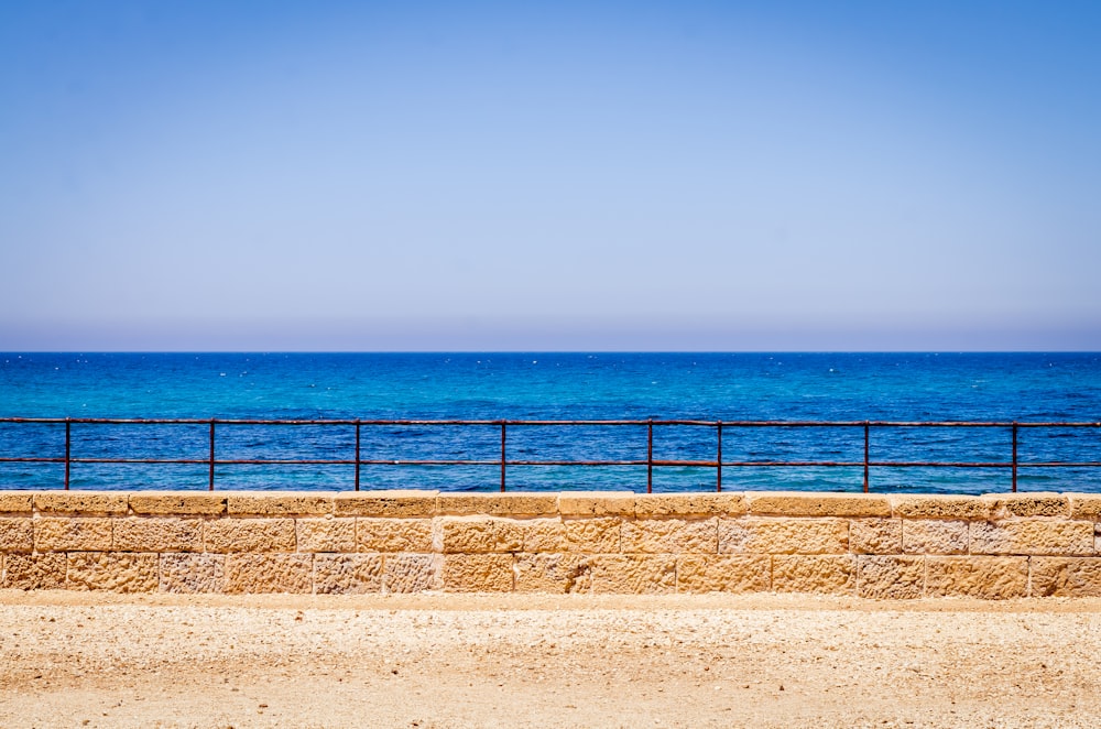 bricked and metal framed rail by sea during daytime