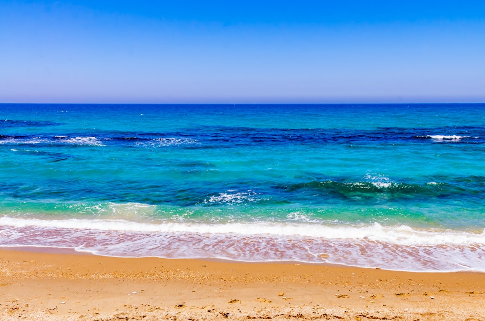 waves crashing on shore during daytime