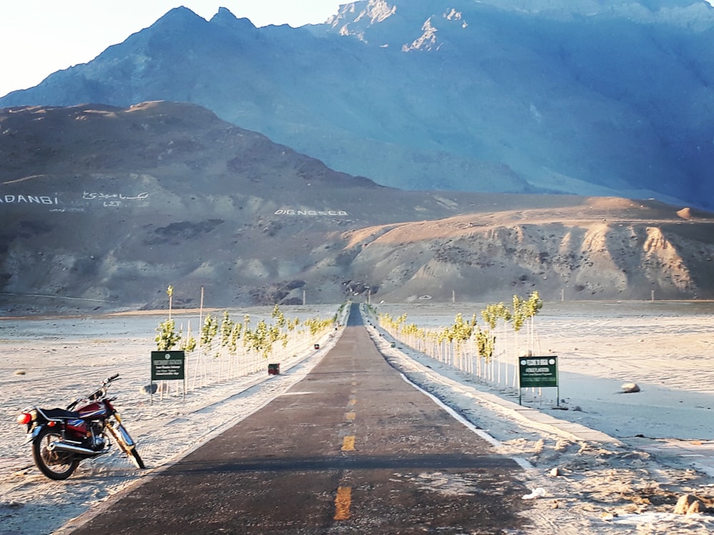 motorcycle parked at the side of the road during day