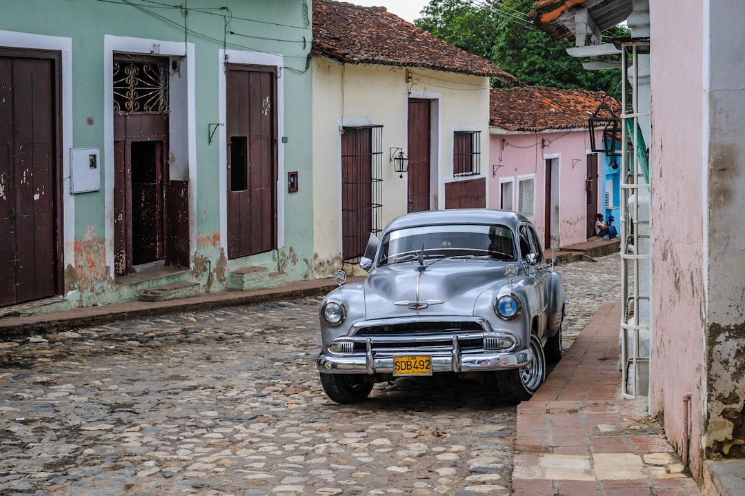 silver vehicle beside building during daytime