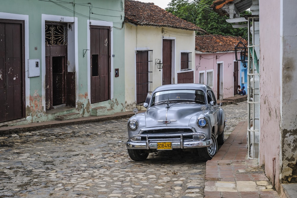 silver vehicle beside building during daytime