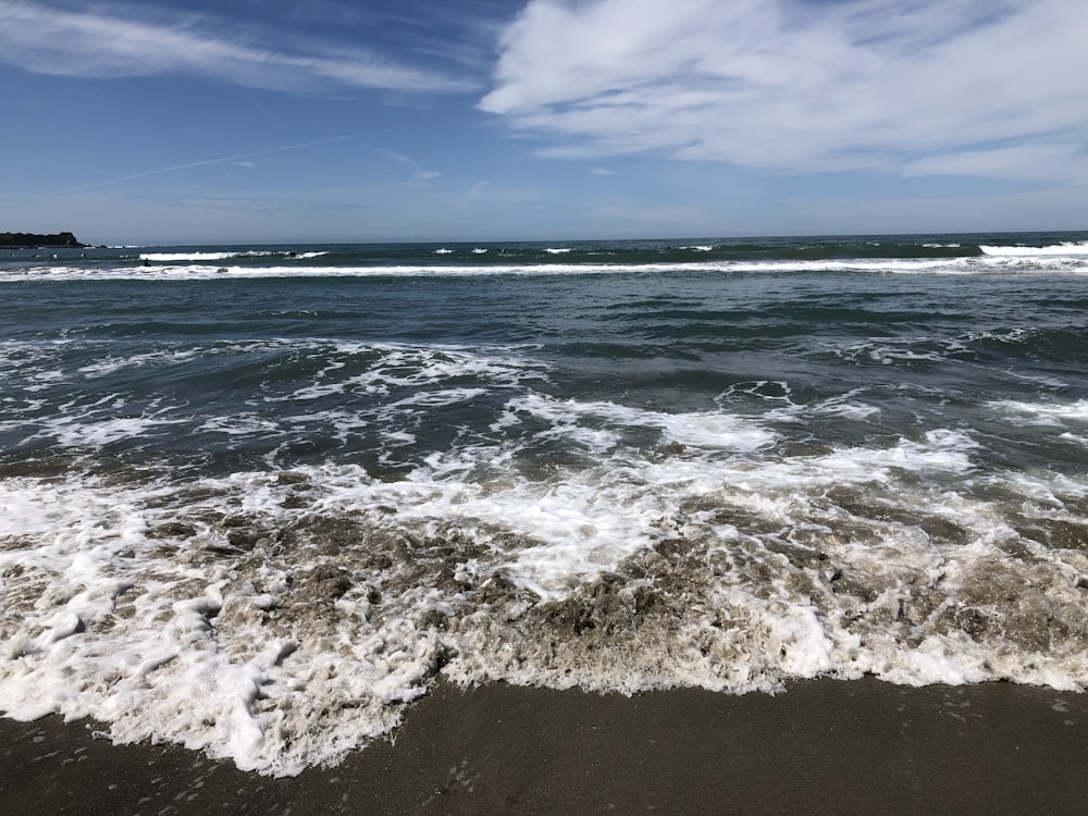 waves crashing on shore during daytime