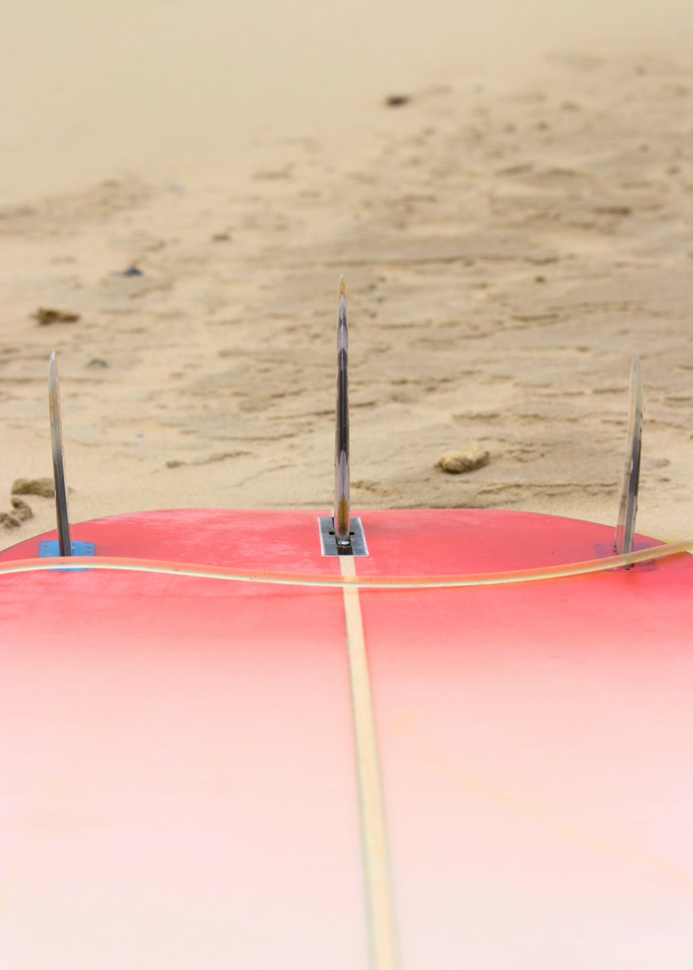 a surfboard is laying on the beach with two poles sticking out of it