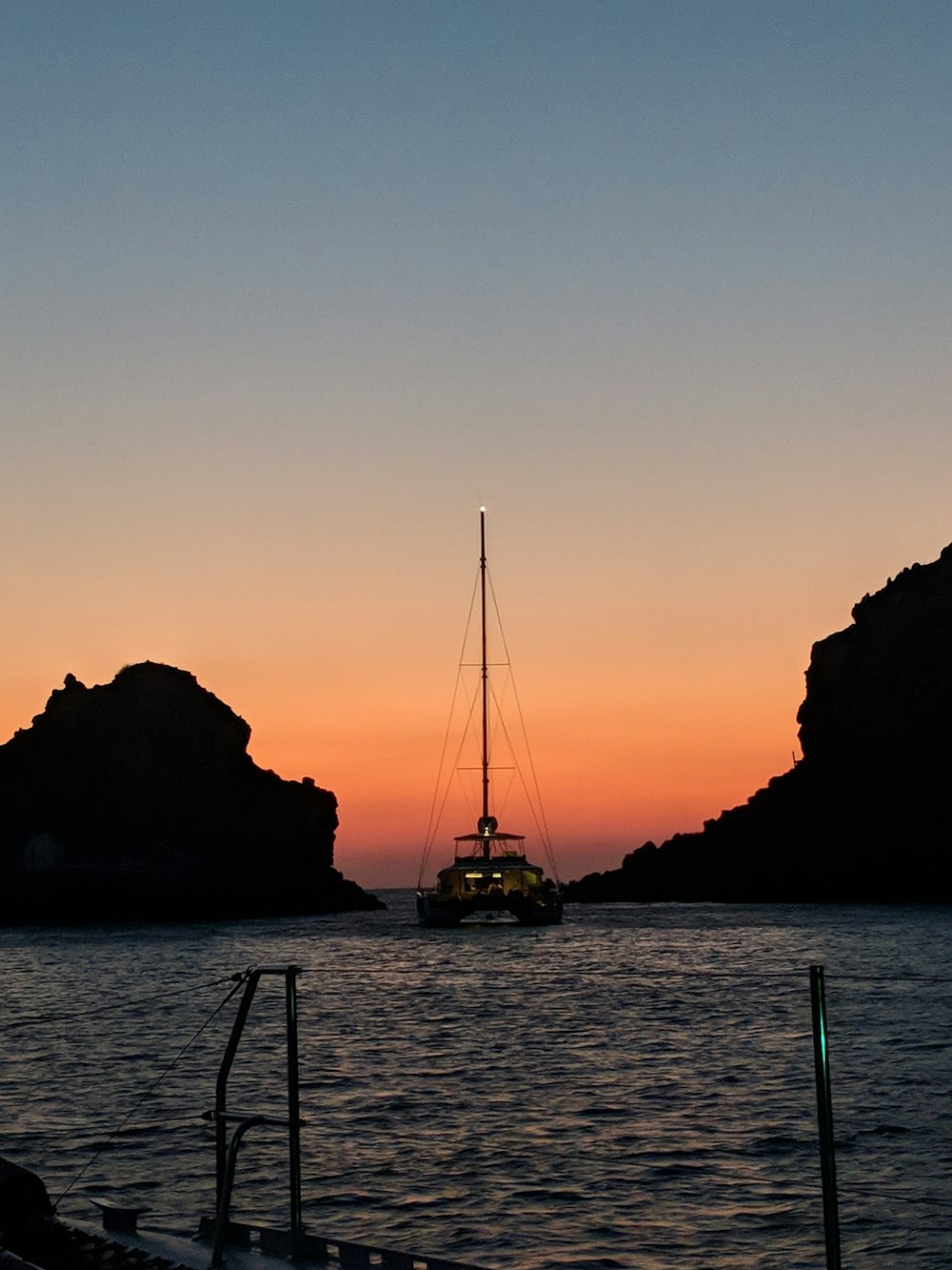 boat by mountain silhouette during golden hour