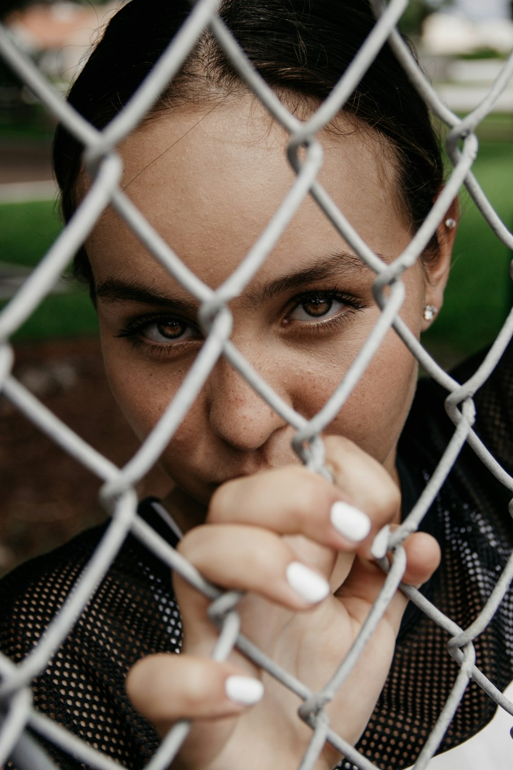 woman holding on iron wire fence