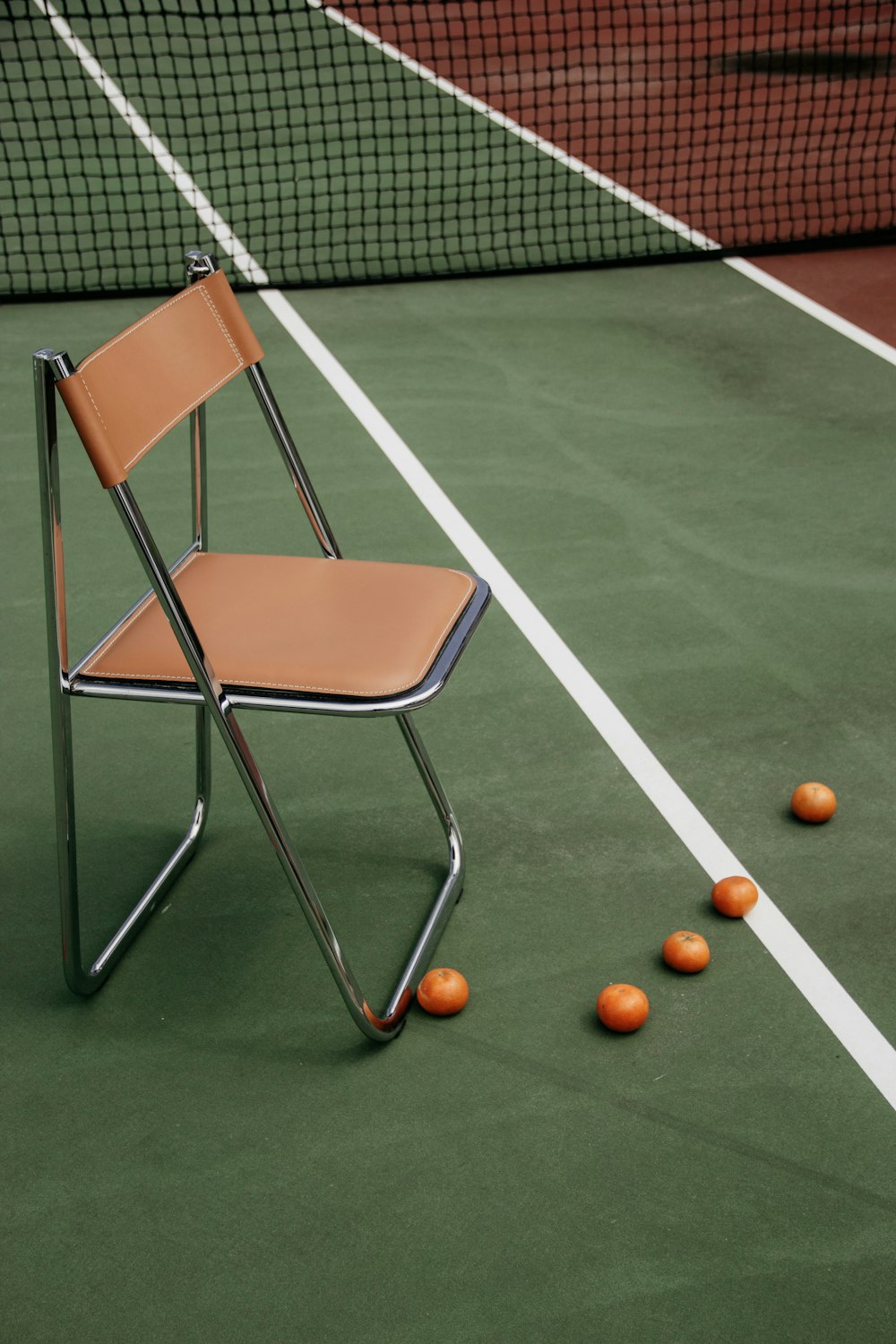 brauner ledergepolsterter armloser Stuhl auf dem Tennisplatz
