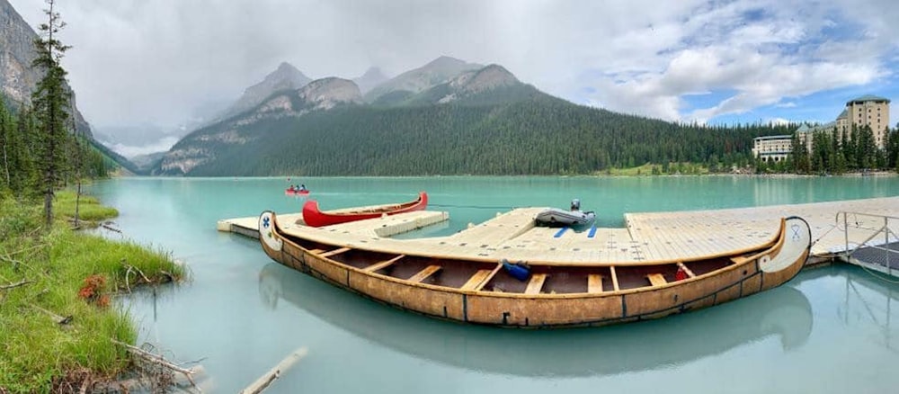 brow canoe on calm body of water during daytime