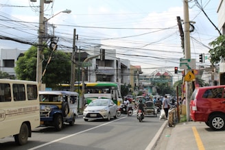 A bustling city street with diverse transport modes including buses, bikes, and electric cars.